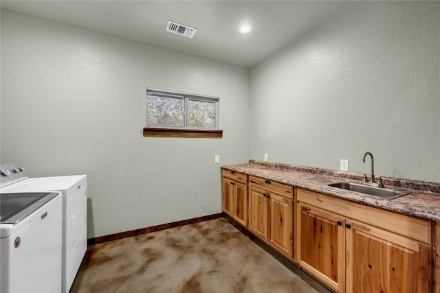 clothes washing area featuring sink, washer and clothes dryer, dark colored carpet, and cabinets