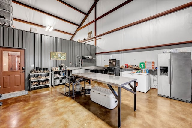 kitchen featuring beam ceiling, stainless steel refrigerator with ice dispenser, and high vaulted ceiling