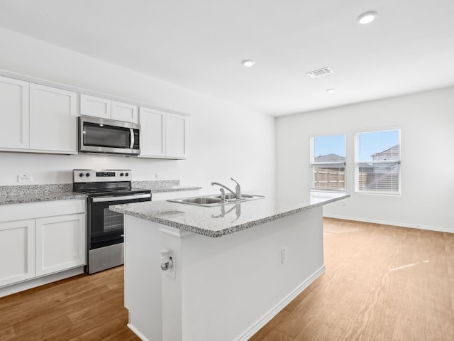 kitchen featuring white cabinetry, light hardwood / wood-style flooring, a kitchen island with sink, and appliances with stainless steel finishes