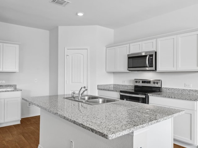 kitchen with a kitchen island with sink, dark wood-type flooring, sink, appliances with stainless steel finishes, and white cabinetry