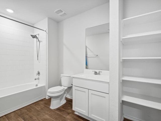 full bathroom with hardwood / wood-style floors, vanity, toilet, and tiled shower / bath