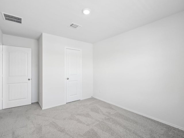 unfurnished bedroom featuring light carpet and a closet