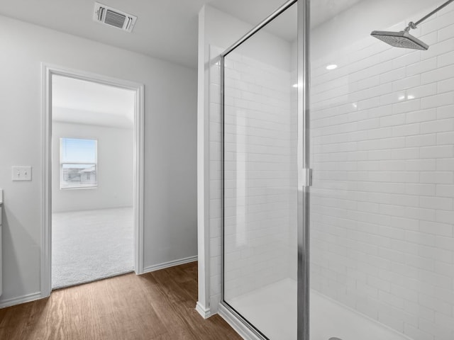 bathroom featuring walk in shower and hardwood / wood-style flooring