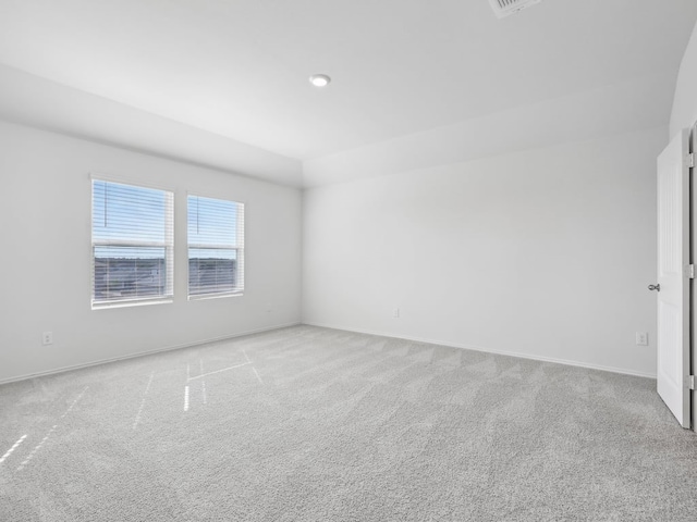 carpeted empty room featuring vaulted ceiling