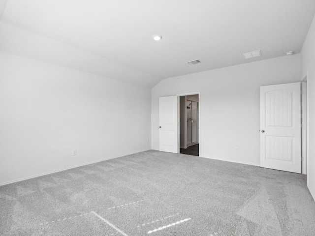 carpeted spare room with lofted ceiling