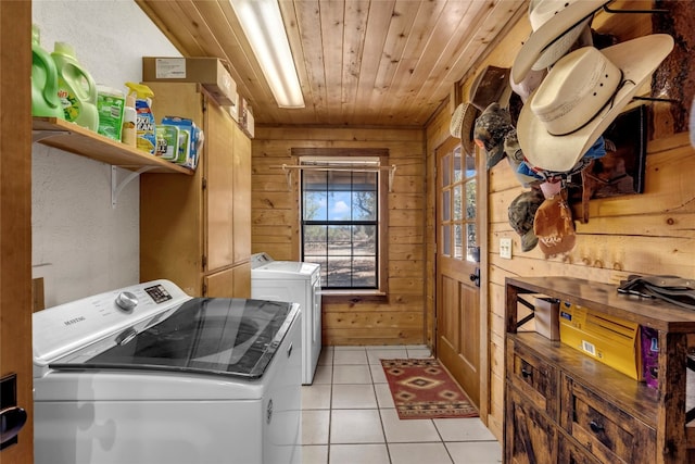 laundry area with light tile patterned flooring, wooden walls, wooden ceiling, and separate washer and dryer