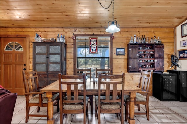 tiled dining space with wood walls, beverage cooler, and wooden ceiling