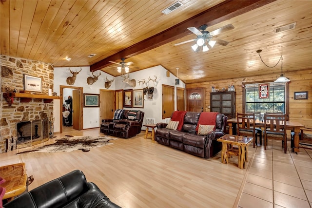 living room featuring a stone fireplace, light hardwood / wood-style flooring, wooden ceiling, lofted ceiling with beams, and ceiling fan