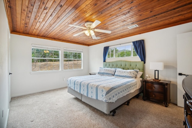 carpeted bedroom with ornamental molding, ceiling fan, and wooden ceiling