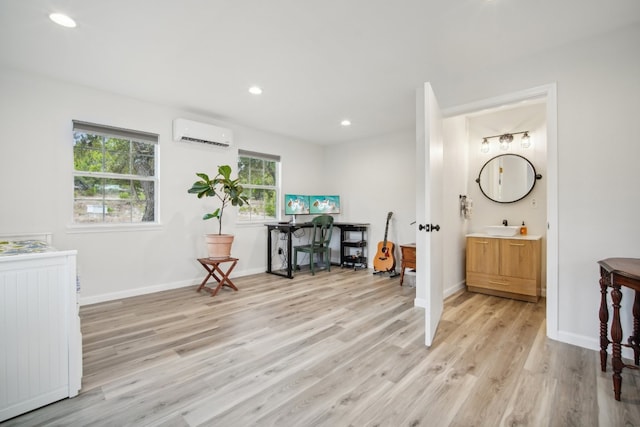 entrance foyer featuring sink, a wall mounted AC, and light hardwood / wood-style floors