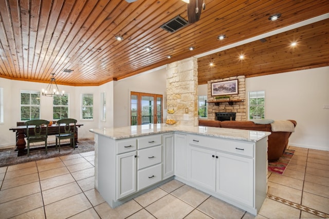 kitchen with wood ceiling, vaulted ceiling, plenty of natural light, and white cabinets