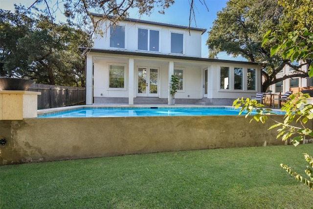 back of house featuring a lawn and french doors