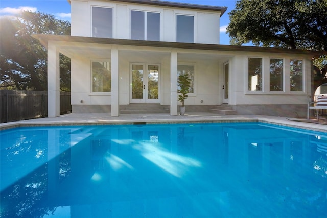 view of swimming pool with french doors