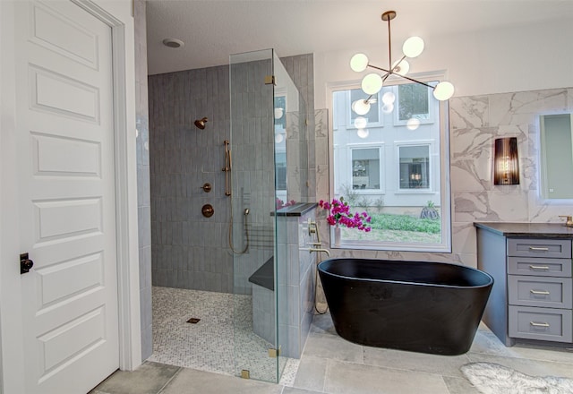 bathroom with a notable chandelier, vanity, tile walls, and plus walk in shower