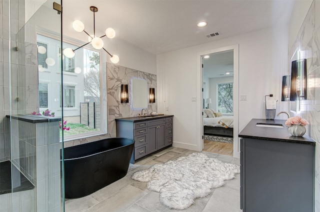 bathroom featuring a chandelier, vanity, and tile walls