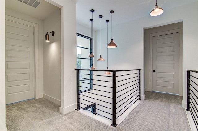 hall with light colored carpet