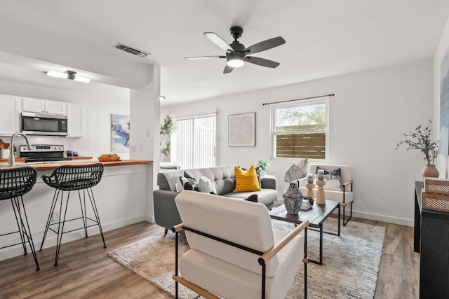 living room featuring hardwood / wood-style flooring and ceiling fan