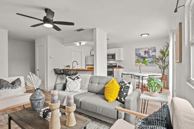 5616 Emerald Forest Dr Unit 101, Austin, TX 78745 - living room featuring light wood-style flooring, ceiling fan, and baseboards
