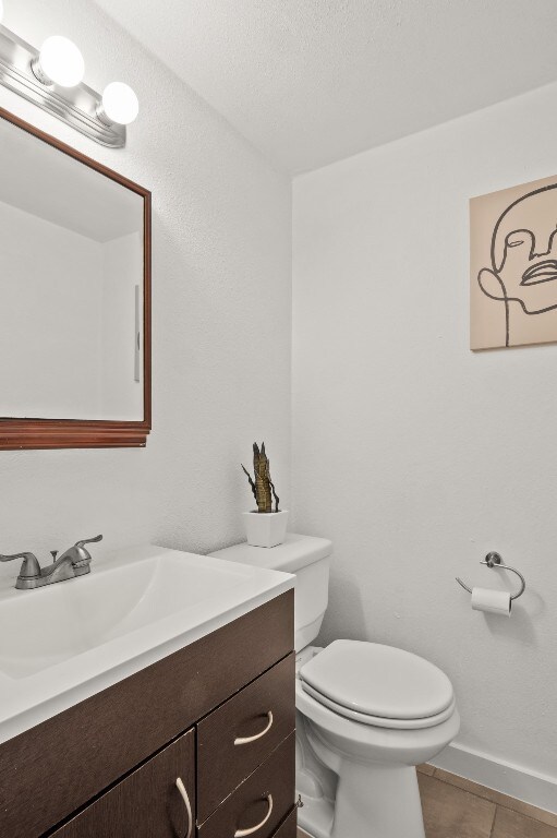 bathroom featuring tile patterned flooring, vanity, and toilet