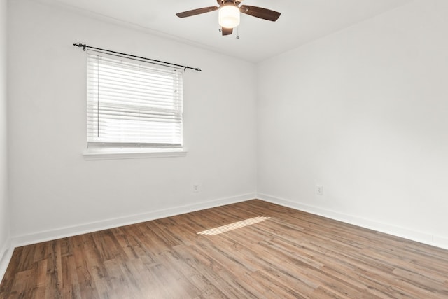 empty room with hardwood / wood-style floors and ceiling fan