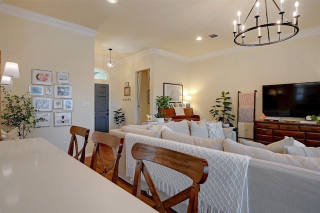 living room featuring an inviting chandelier, ornamental molding, and hardwood / wood-style flooring