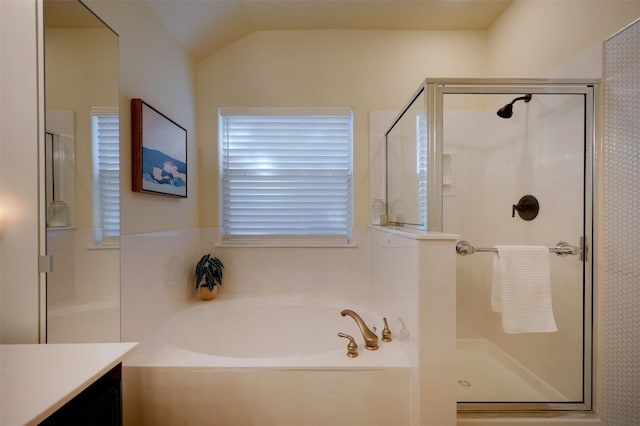 bathroom featuring vanity, vaulted ceiling, and independent shower and bath