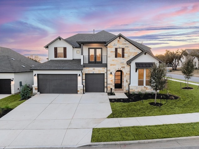 view of front of home with a garage, a lawn, and a balcony