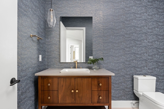 bathroom featuring vanity, toilet, and vaulted ceiling