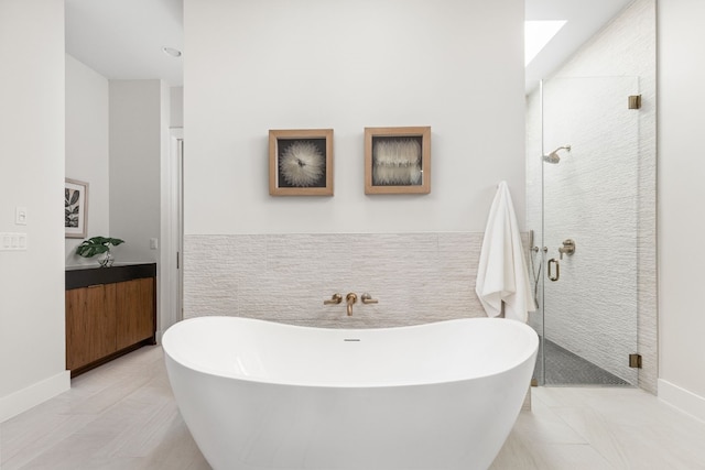 bathroom with vanity, tile walls, and shower with separate bathtub