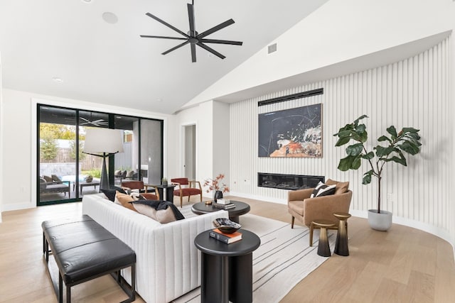 living room with ceiling fan, high vaulted ceiling, and light hardwood / wood-style flooring