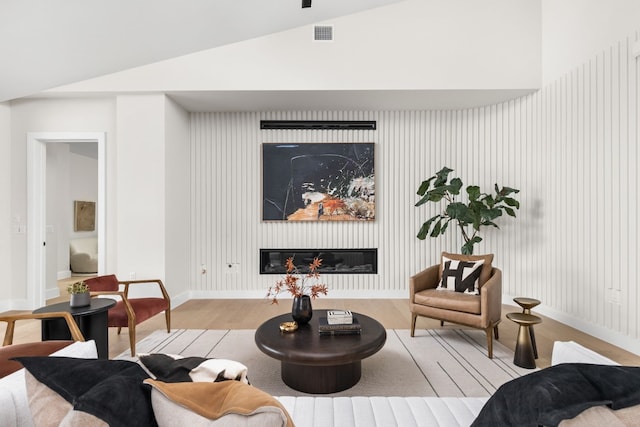 living room with light wood-type flooring and lofted ceiling