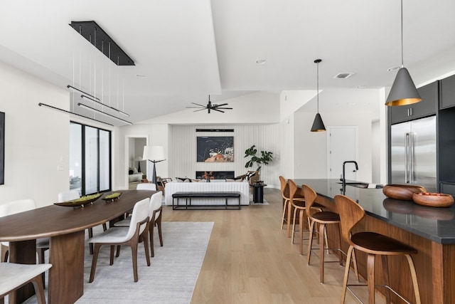 dining area with ceiling fan, light hardwood / wood-style floors, and sink