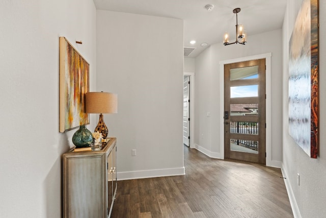 foyer featuring dark hardwood / wood-style flooring and an inviting chandelier