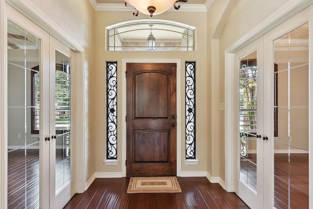 foyer featuring ornamental molding, french doors, dark hardwood / wood-style floors, and plenty of natural light