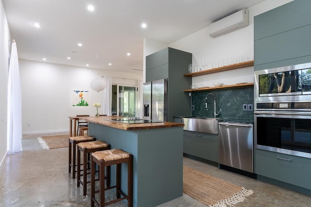 kitchen with sink, wooden counters, appliances with stainless steel finishes, a wall unit AC, and tasteful backsplash