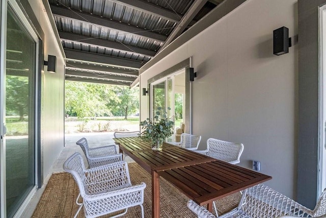 sunroom / solarium featuring beam ceiling