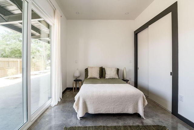 bedroom with access to exterior and concrete flooring