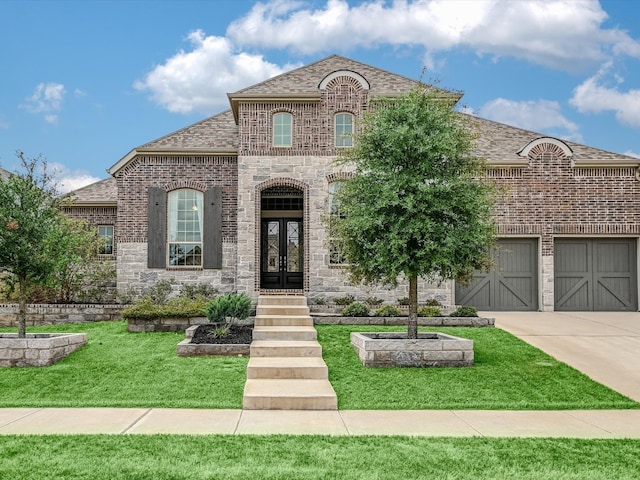 french provincial home with a garage and a front lawn