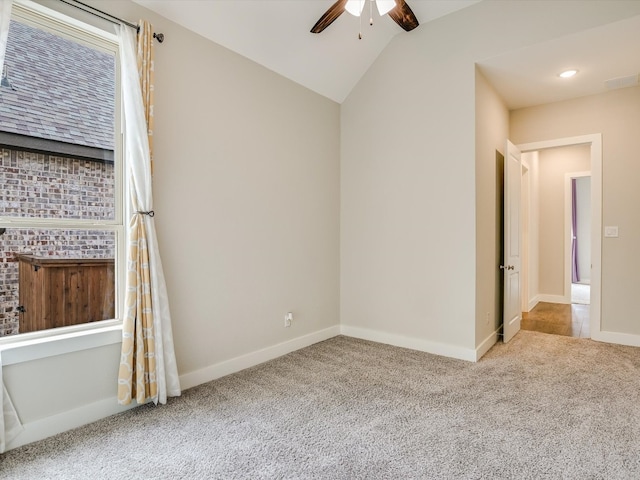 empty room featuring lofted ceiling, carpet, and ceiling fan