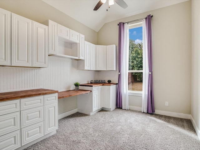 kitchen featuring wood counters, white cabinetry, light carpet, and lofted ceiling