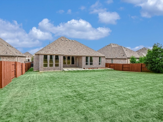 rear view of property featuring a patio and a lawn