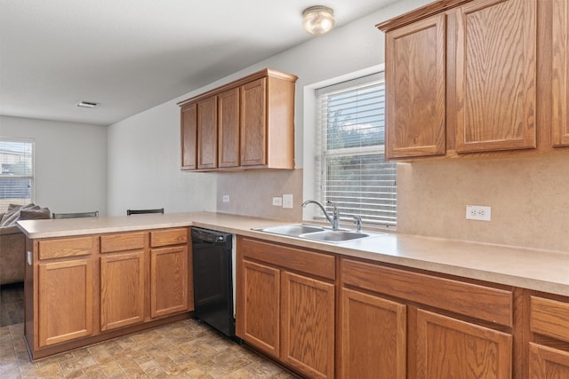 kitchen with kitchen peninsula, black dishwasher, sink, and a wealth of natural light