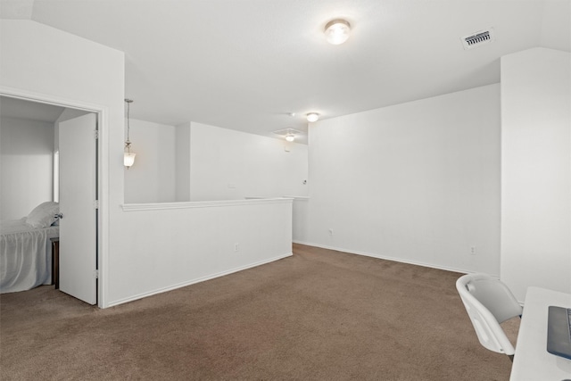 carpeted empty room with lofted ceiling