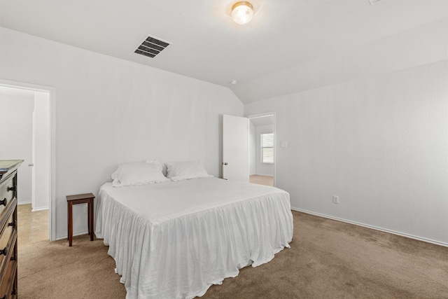 bedroom featuring lofted ceiling and light colored carpet