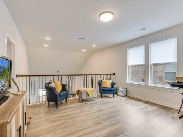 sitting room featuring lofted ceiling and light wood-type flooring