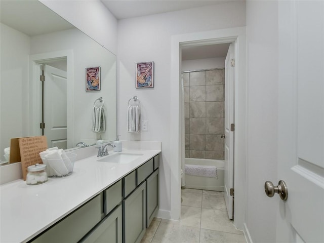 bathroom featuring tile patterned flooring, vanity, and tiled shower / bath