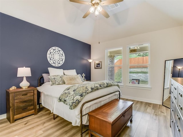 bedroom featuring ceiling fan, light hardwood / wood-style floors, and vaulted ceiling