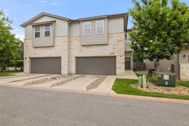 view of front of property featuring central AC unit and a garage