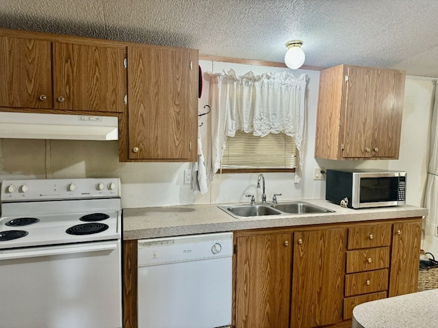 kitchen with white appliances, a textured ceiling, and sink