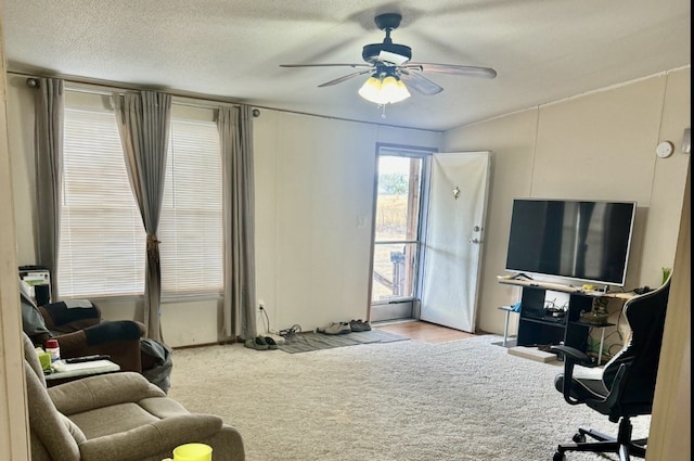 carpeted living room featuring a textured ceiling and ceiling fan